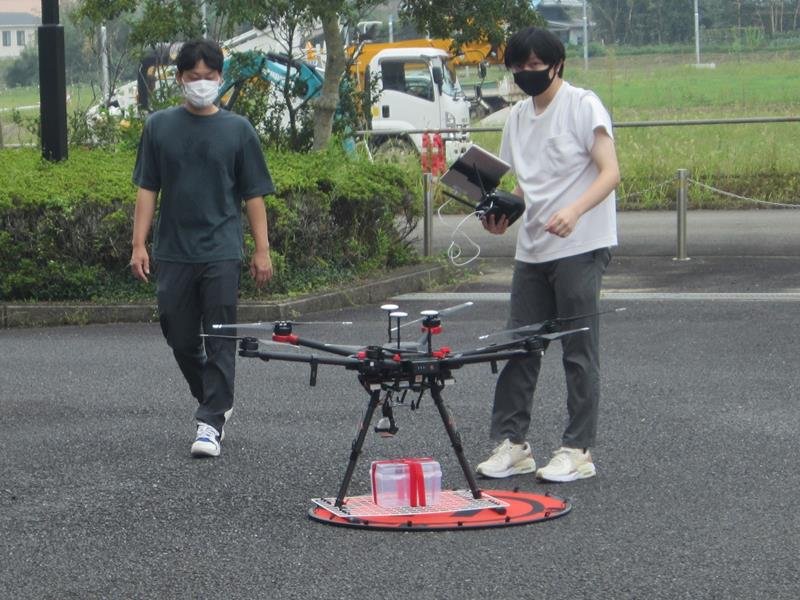 ドローンを使った運搬を実演するロビジ職員＝睦沢町
