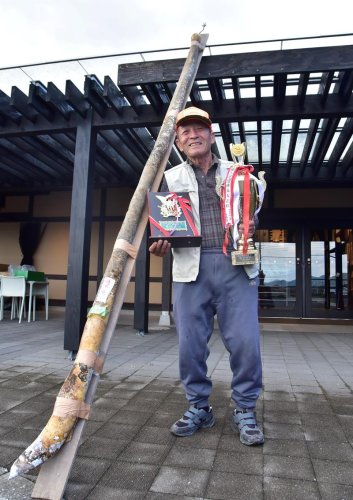 ２９５センチまで育てたヒョウタンと優勝カップ、盾を持つ高梨さん
