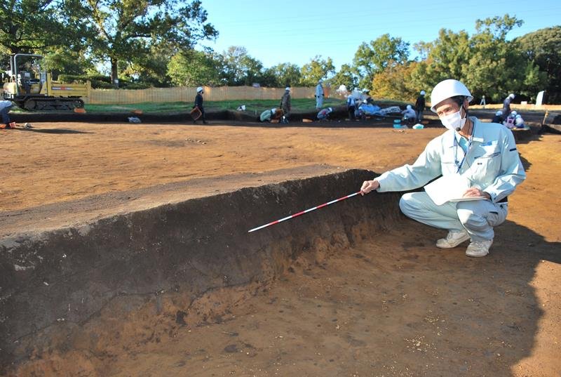 くぼ地部分の土の堆積状況を説明する松田さん＝５日、千葉市若葉区の加曽利貝塚
