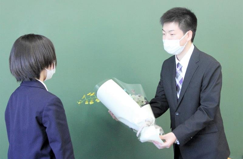 簿記部の後輩から花束を受け取る本橋さん（右）＝千葉市中央区
