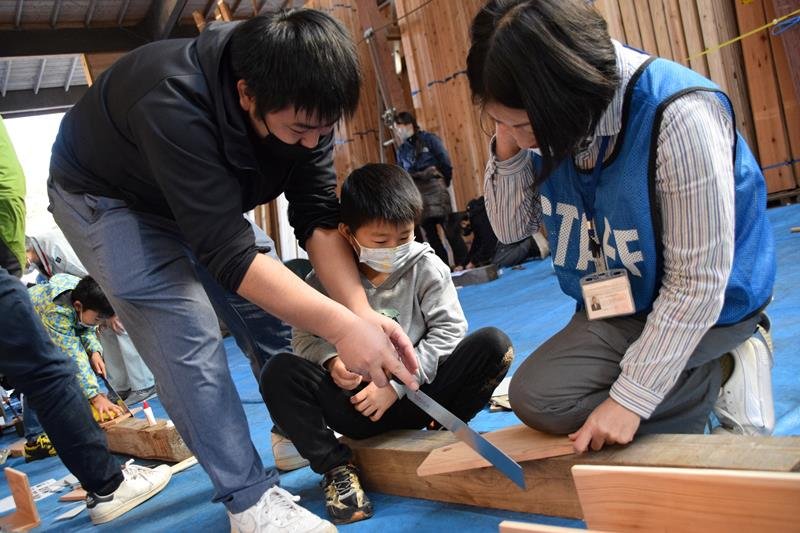 講師（右）の指導で木工作を体験する親子＝東金市
