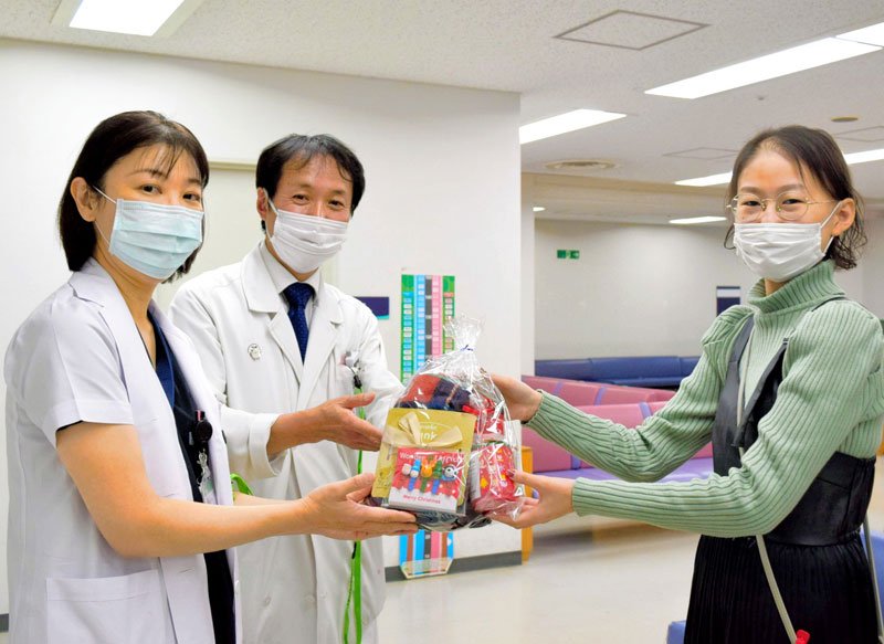 クリスマスプレゼントを贈る土井優奈さん（右）＝１３日、千葉大病院
