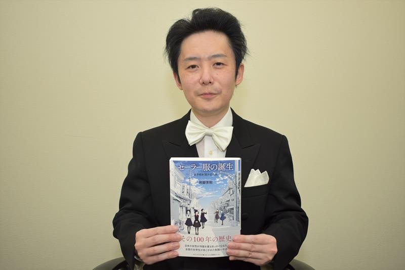 自著「セーラー服の誕生　女子校制服の近代史」を手にする刑部芳則准教授＝千葉市中央区
