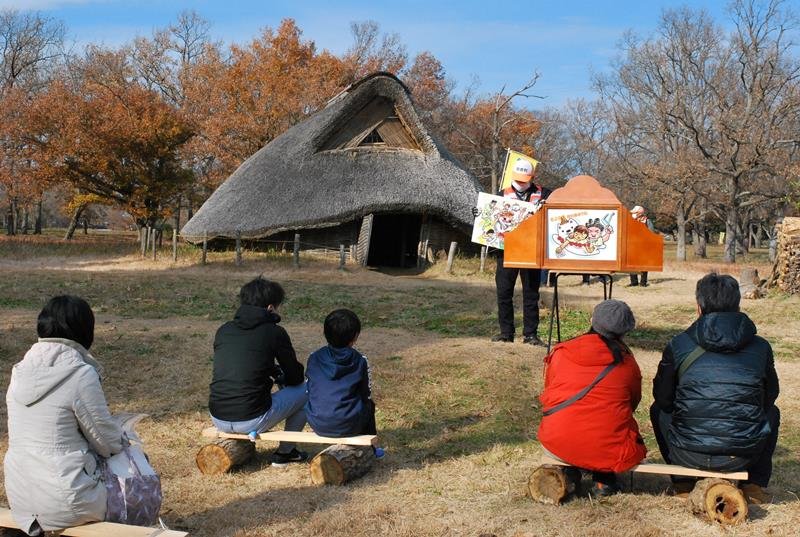 縄文人の暮らしを伝える紙芝居を見る親子ら＝昨年１２月１２日、千葉市若葉区の加曽利貝塚
