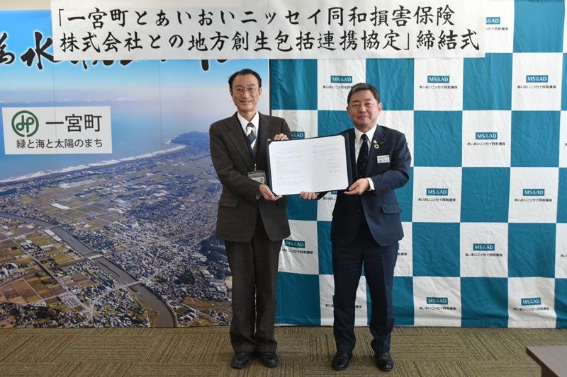 サインした協定書を持つ馬淵町長（左）と本田支社長＝一宮町