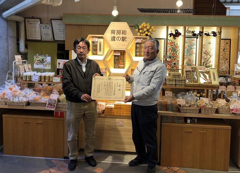 賞状を掲げる「ちば南房総」の加藤文男副社長（右）と鈴木賢二統括部長（南房総市提供）

