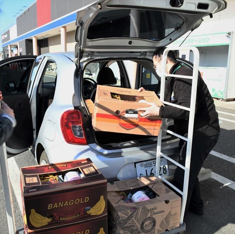スーパーで自宅療養者らへ届ける支援物資を車に積み込む職員＝１日、富里市
