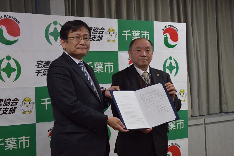 協定書を交わす神谷市長（左）と石川支部長＝千葉市役所
