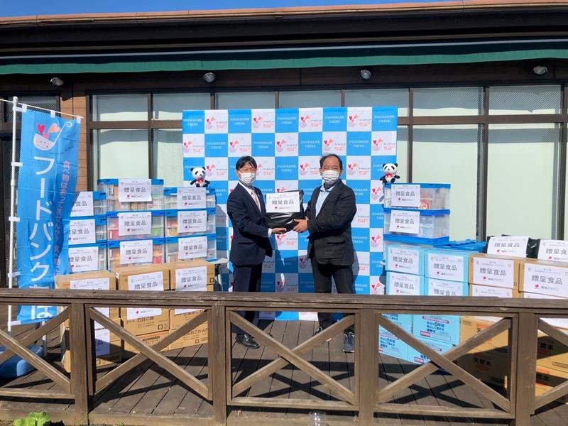 菊地代表（右）に食品を手渡す篠原部長＝千葉市中央区

