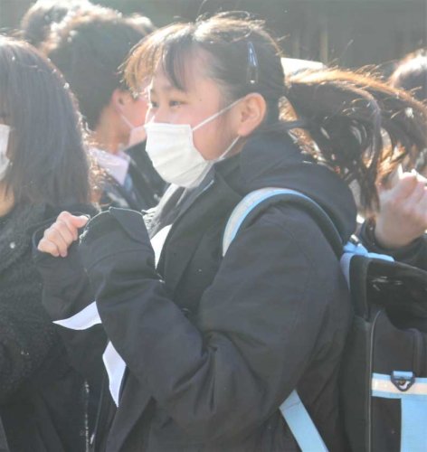 張り出された合格者番号を確認して喜ぶ受験生＝７日午前９時ごろ、千葉市中央区の県立千葉高校
