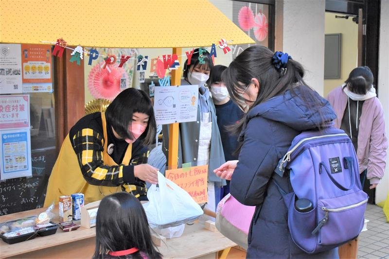 月に１回実施している食事の配布活動「トモ飯」でお弁当を配る田中代表（左）＝千葉市若葉区
