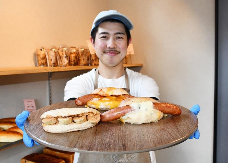 ＪＡＬスカイと共同開発したホットサンドを手にする新井専務＝香取市
