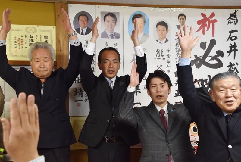 当選が決まり、支援者らと万歳する石井氏（中央）＝１７日午後１１時１５分ごろ、南房総市千倉町北朝夷
