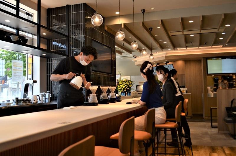 席の有料予約制度を導入したハンドドリップカウンターでコーヒーを入れる梶オーナー。約２カ月休店して改装した＝船橋市本町１
