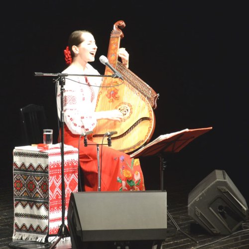 民族楽器のバンドゥーラを弾きながら歌うナターシャさん＝千葉市美浜区