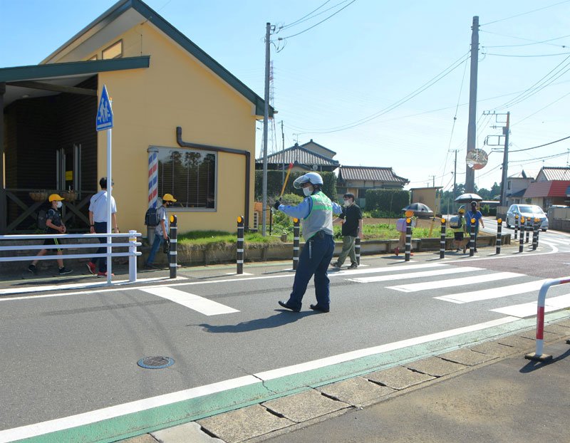 ガードパイプが設置された通学路で見守り活動を行う佐倉署員＝２８日午後３時ごろ、八街市
