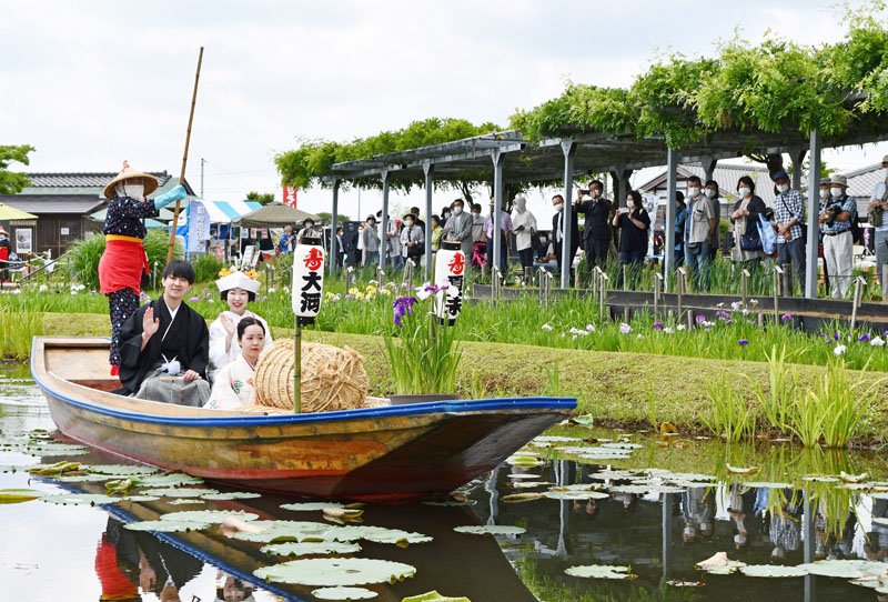 香取市の水郷佐原あやめパークで４日、花嫁と花婿が手こぎの和船「さっぱ舟」に乗り晴れ姿をお披露目するイベント「嫁入り舟」が行われ、観光客らが２人の門出を祝った