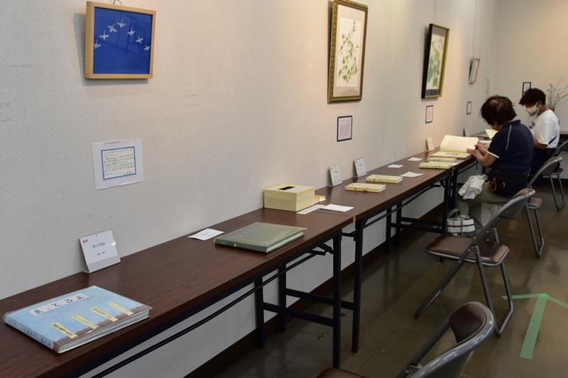 絵本を楽しむ来場者ら。会場には各作品を象徴する絵が展示されている＝四街道市
