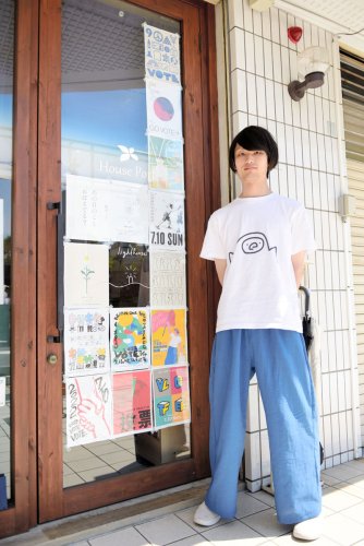 店の玄関ドアに投票を呼び掛けるポスターを貼った関口さん＝千葉市花見川区の「本屋ｌｉｇｈｔｈｏｕｓｅ幕張支店」