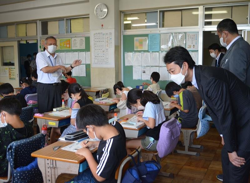 専科教員（左）による算数の授業を視察する熊谷知事（右手前）＝８日、船橋市

