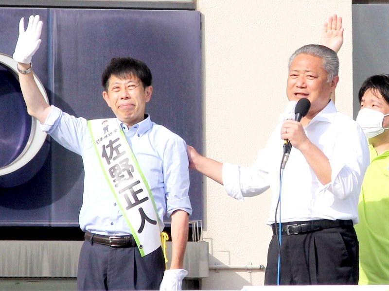 馬場共同代表（左から２人目）の応援を受け、手を振る佐野氏＝６月２４日、ＪＲ津田沼駅前