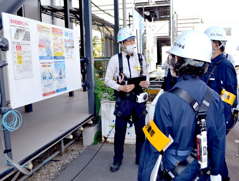 千葉市役所新庁舎建設現場で熱中症指数モニターを確認した千葉労働局の職員ら＝千葉市中央区