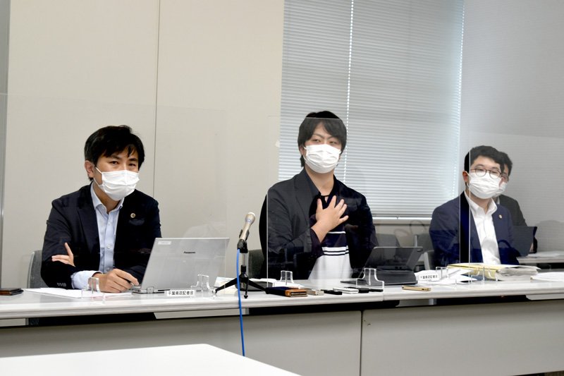 記者会見で過酷な労働環境を訴える飯島さん（中央）＝２１日午後、千葉県庁