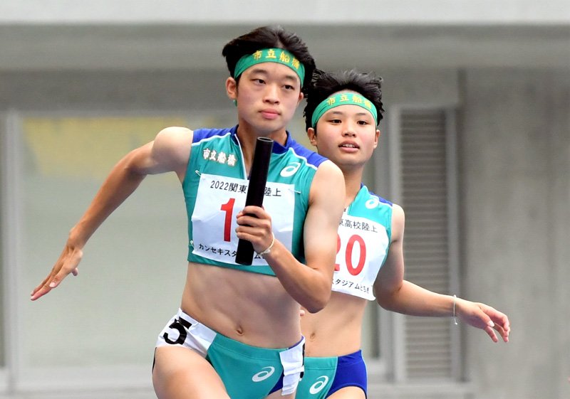 女子４００メートルリレーでバトンをつなぐ市船橋の３走山田裕未（右）と４走佐藤葵唯＝６月１８日、カンセキ