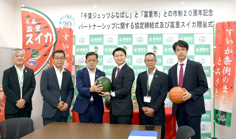 パートナーシップの締結式に参加した千葉ジェッツの田村社長（中央右）と五十嵐市長（同左）＝富里市役所
