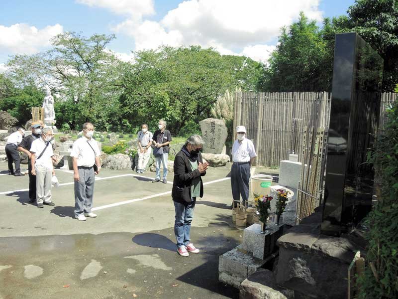 「福田村事件」現場近くの追悼慰霊碑前で命日墓参会が開かれた。手前は、映画「福田村事件」（仮題）製作者の小林さん＝６日、野田市