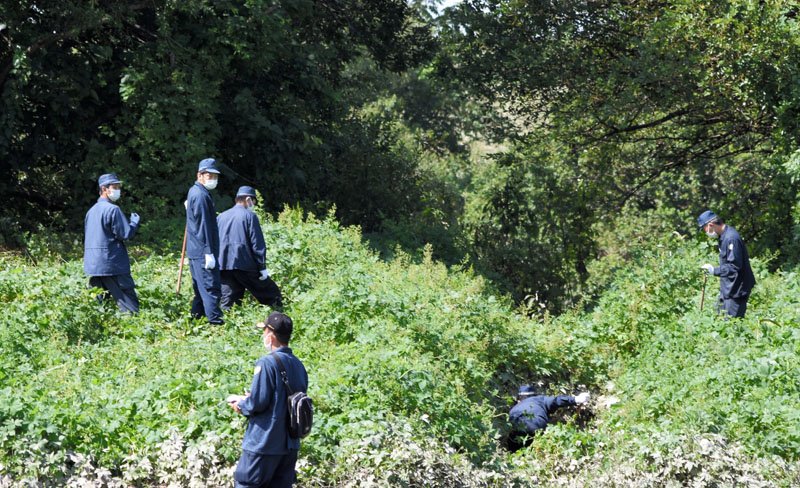 南さんの靴と靴下が見つかった江戸川河川敷の草地を捜索する警察官＝２８日午前１１時２５分ごろ、流山市