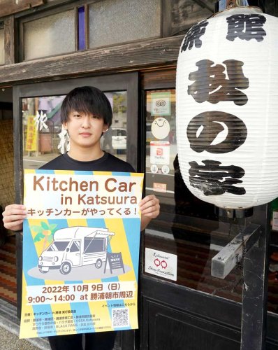 キッチンカーイベントの案内ポスターを持つ北崎さん＝勝浦市