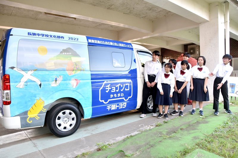 自分たちが描いた絵でラッピングされた「チョイソコかもがわ」の車両と長狭学園の生徒＝鴨川市