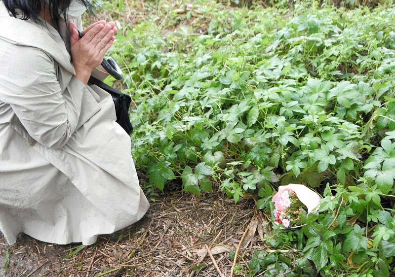 南さんの靴が見つかった場所の近くに花を手向ける女性＝６日午後１時半ごろ、流山市