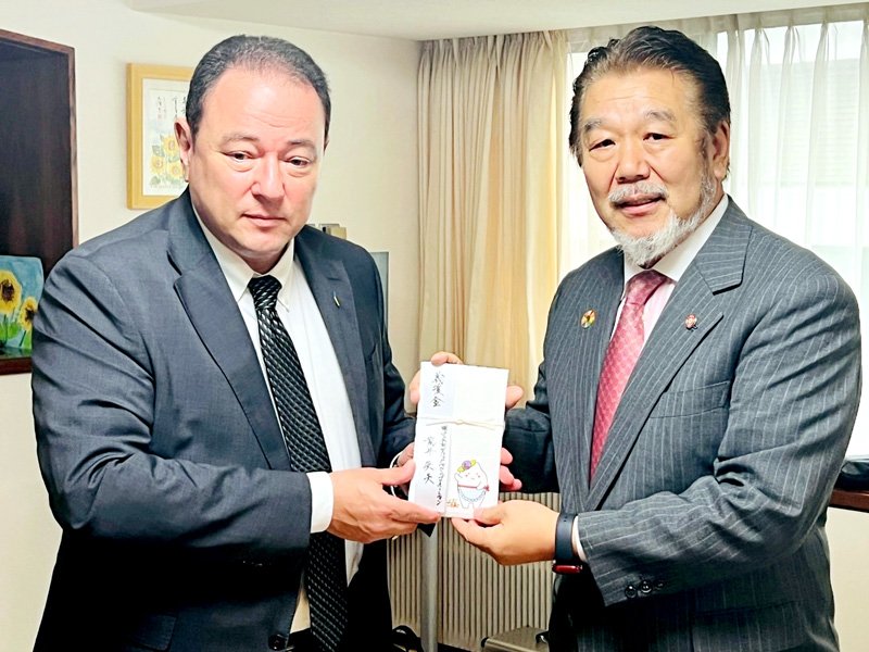 セルギー・コルスンスキー駐日大使（左）に義援金を手渡した荒井会長＝ウクライナ大使館（アルファ・ジャパンプロモーション提供）