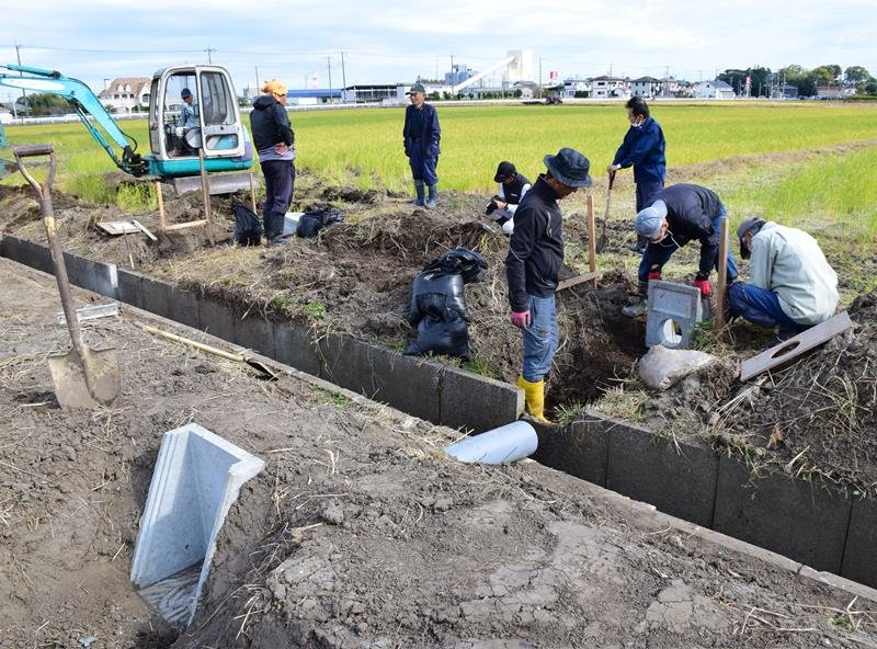 調整板をはめる落水升やパイプを設置する早野地域資源保全会のメンバーら＝５日、茂原市
