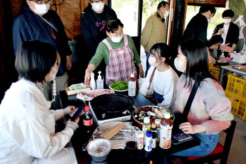 生産者から豚肉の説明を受けるツアー参加者＝旭市