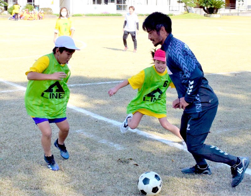 佐藤勇人さんとサッカーを楽しむ児童＝白子町立関小

