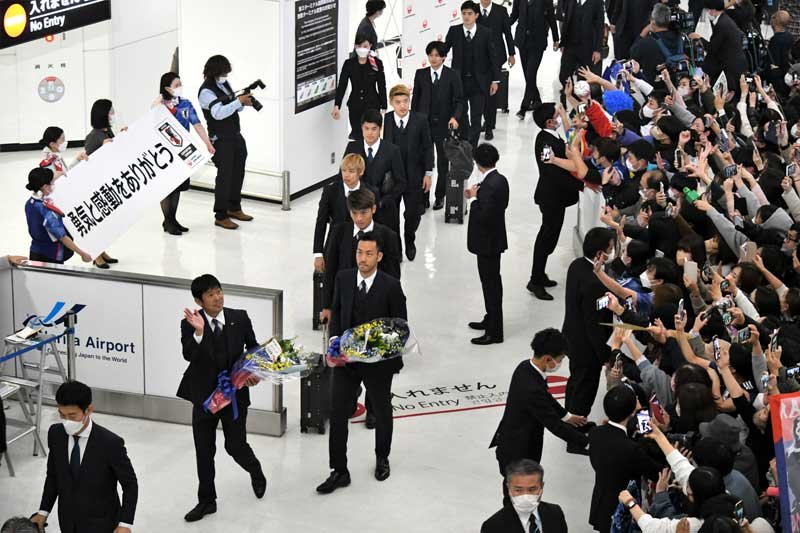 成田空港の到着ロビーで大勢のサポーターに歓迎されるサッカー日本代表＝７日午後６時半ごろ、成田市