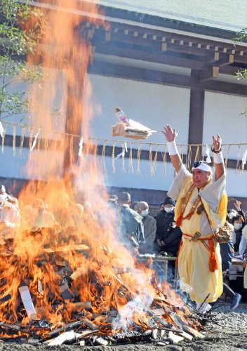 空高く激しく燃える炎に納められた札を投げ入れる成田山新勝寺の僧侶＝２８日、成田市
