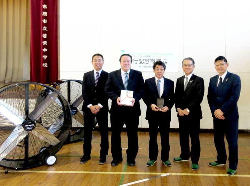 大型循環送風機を贈った山本社長（中央）と、目録を持つ北森校長（左から２人目）ら＝市原市