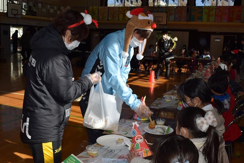 子どもたちに唐揚げを配る西久保選手（中央）ら＝２４日、千葉市緑区
