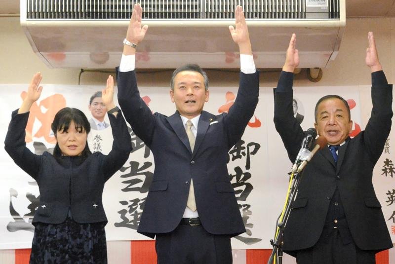 ４選を果たし支持者と万歳する金坂氏（中央）＝１８日夜、大網白里市
