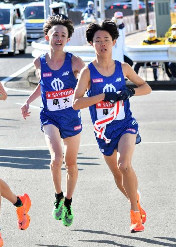 たすきをつなぐ順大の８区・平駿介（左）と９区・藤原優希＝横浜市戸塚区