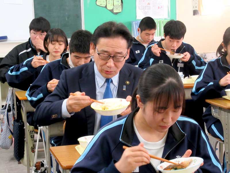 生徒に交じって給食を楽しむ田中市長（中央）＝市川市