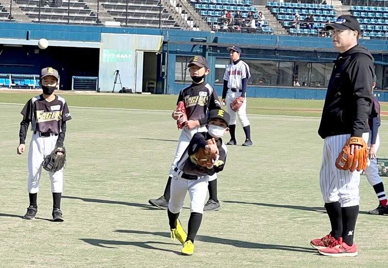 野球教室で、子どもたちに指導する初芝さん（右）＝市原市のゼットエーボールパーク
