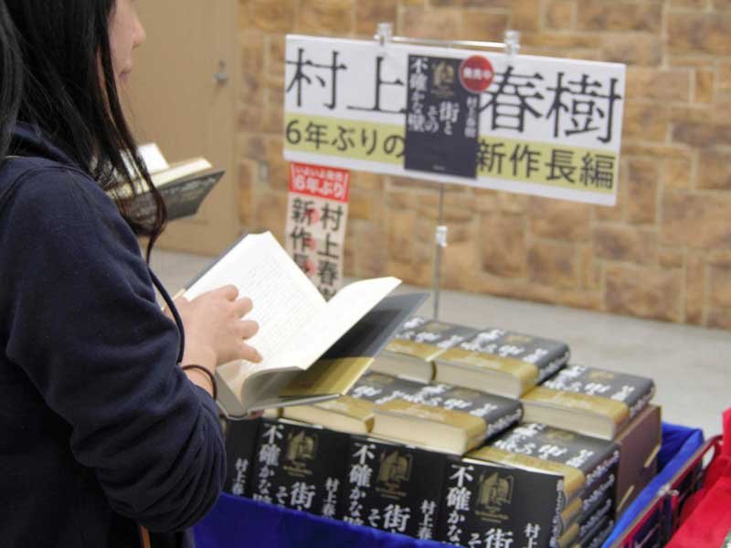 書店内の特設コーナーで新刊を手に取る女性＝１３日、習志野市の丸善津田沼店