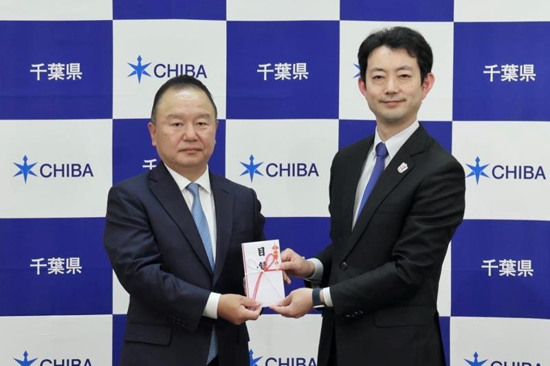 出野社長（左）から目録を手渡された熊谷知事＝千葉県庁
