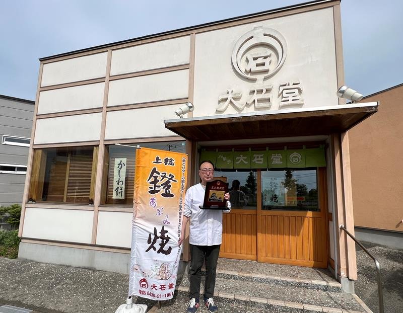 「大石堂」の新店舗で、受賞盾を手にする布施社長＝市原市

