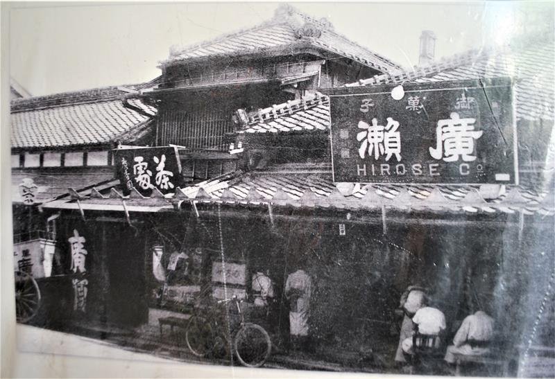 明治時代の店舗の写真。右側の看板を今も保存している
